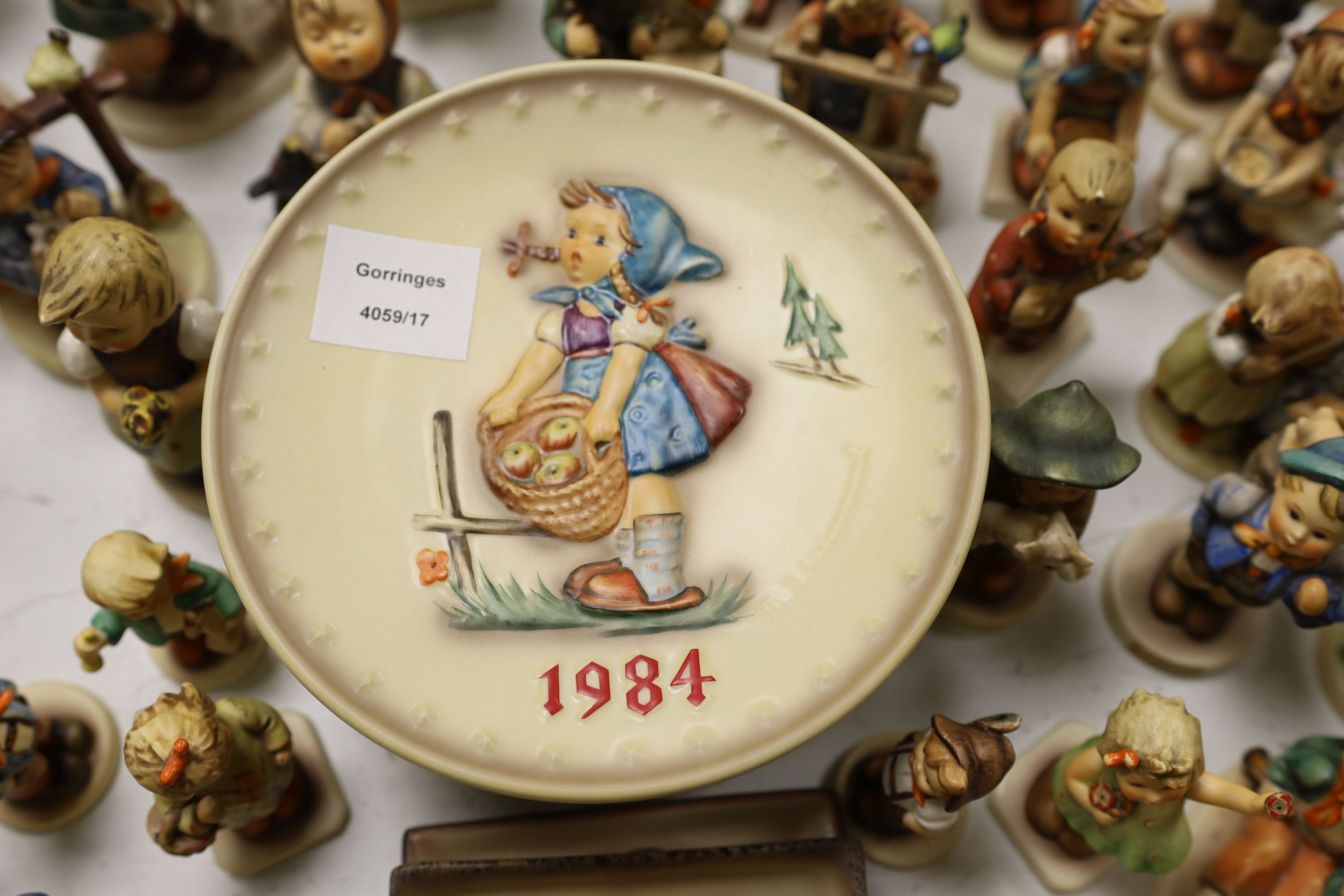 A large collection of Hummel pottery figures, approximately 70 including skier and two similar plaques, some with boxes.